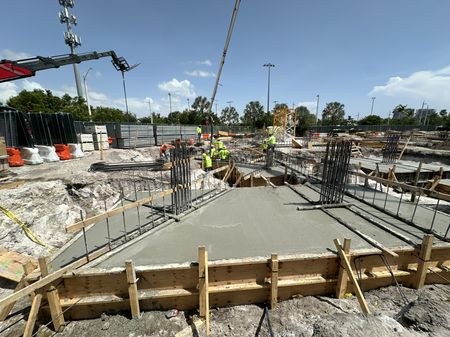 Concrete placement with tower and mobile cranes on site